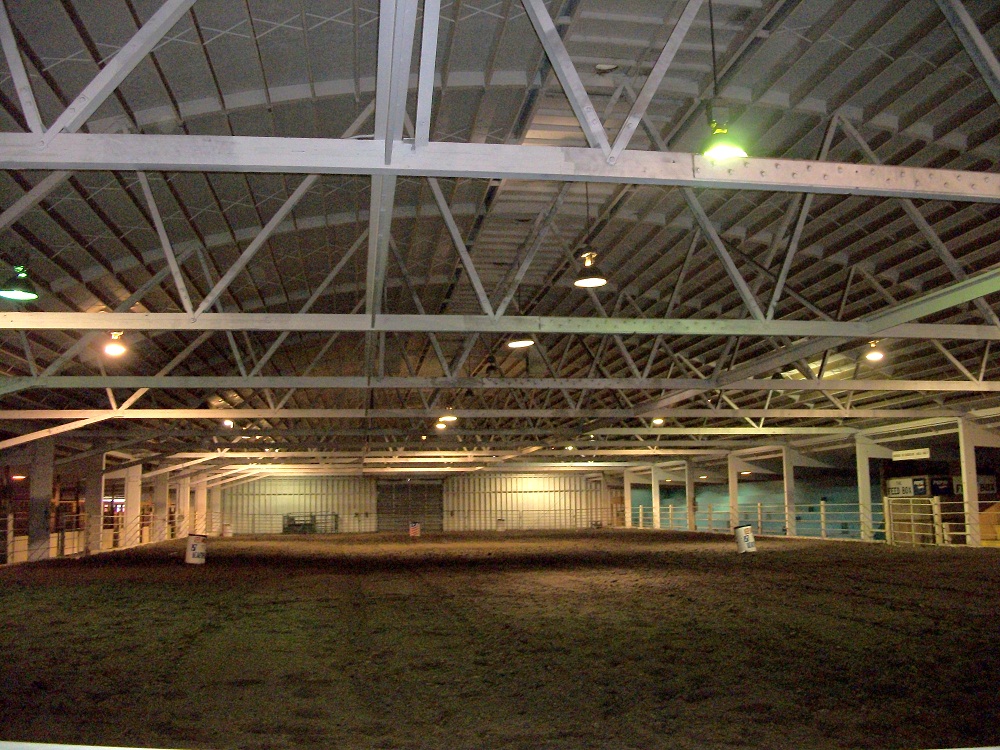 Interior photo of the Hippodrome Arena, empty with dirt floor. 